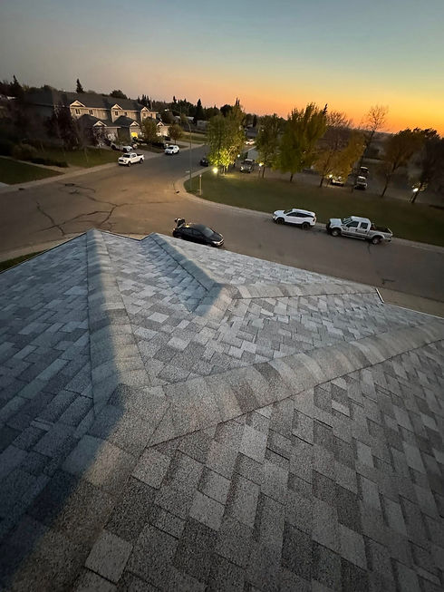 New shingled roof overlooking residential neighborhood at sunset.