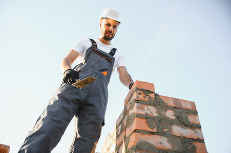 Construction worker using spirit level on brick wall