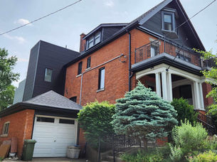 Red brick house with a white garage and black trim.
