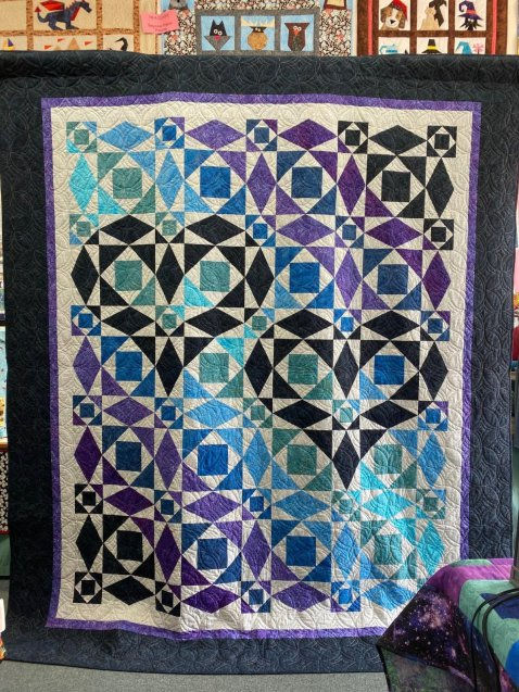 Vibrant quilt with blue and purple geometric pattern