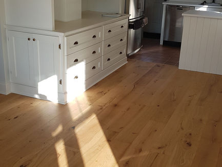 Renovated room with white built-in cabinets, hardwood floors, sunlight