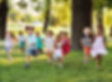 A group of happy children of boys and girls run in the Park on the grass on a Sunny summer