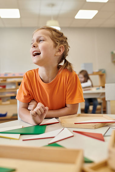 Young girl laughing while learning with geometry shapes