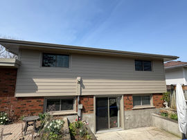 Two-story residential exterior with siding and brick