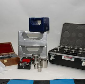 Various laboratory equipment, including weights, scales, and cases, on a white background.