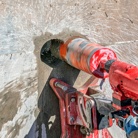 Worker is drilling to concrete wall with core drill machine. Core drills used in metal are called annular cutters.
