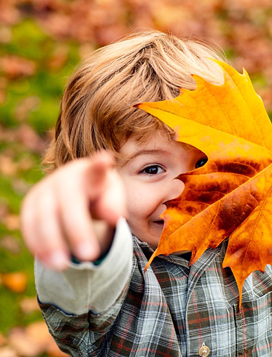 Enfant jouant avec une feuille d'automne en garderie.