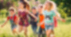 Large group of kids, friends boys and girls running in the park on sunny summer day in cas
