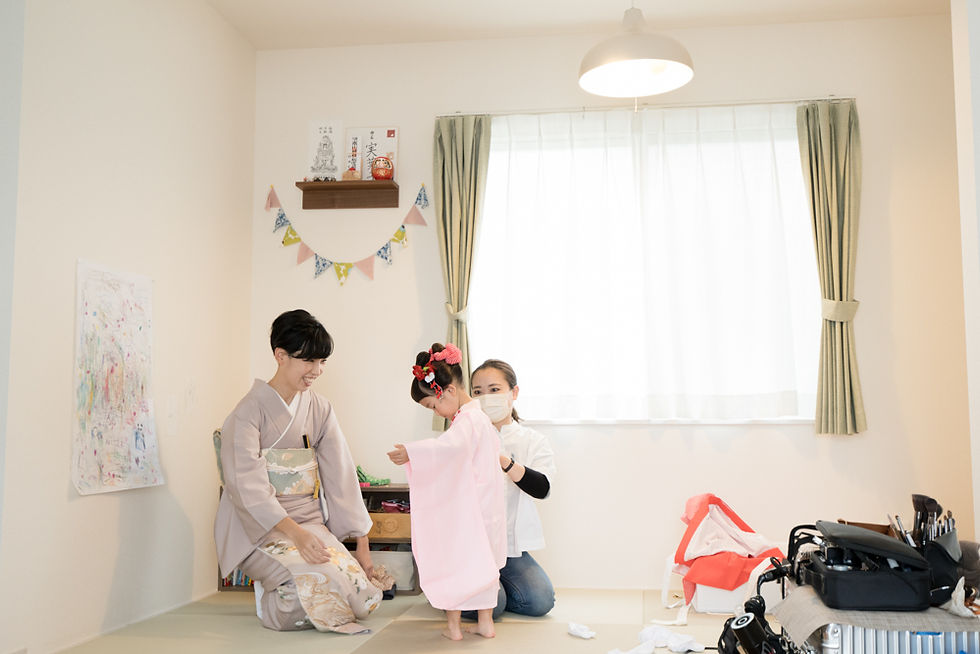 川越市の自宅で七五三のお支度の出張撮影。日本髪を結ってもらった3歳女の子が着付けをされている様子。