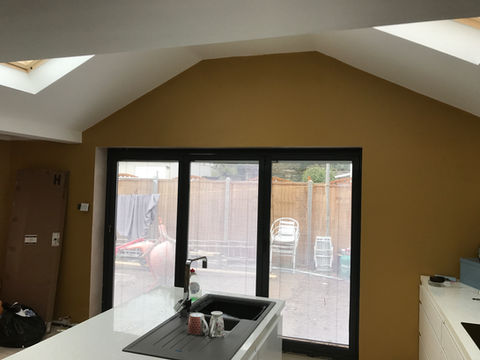 Newly painted mustard kitchen extension with bi-fold doors