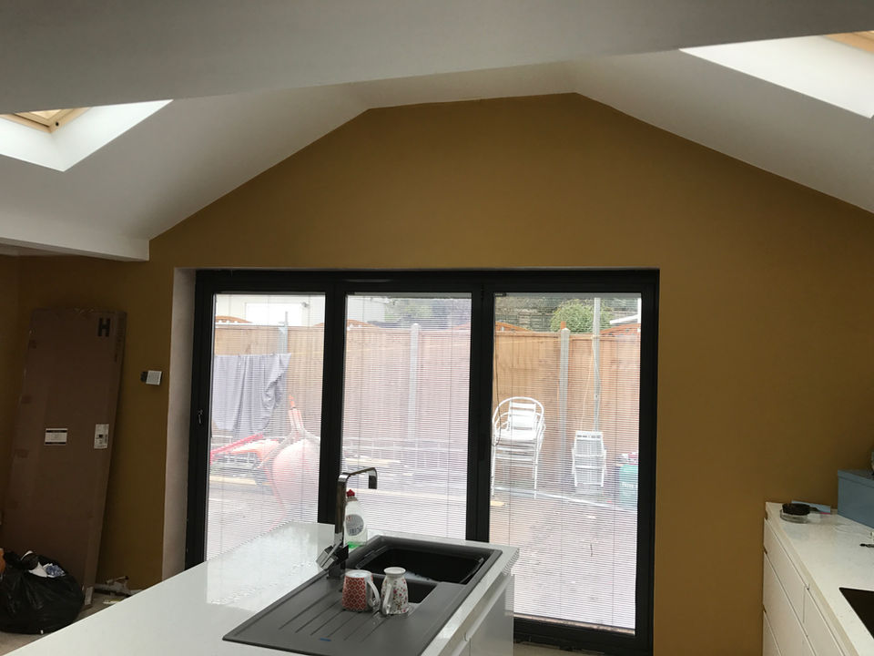 Newly painted mustard kitchen extension with bi-fold doors