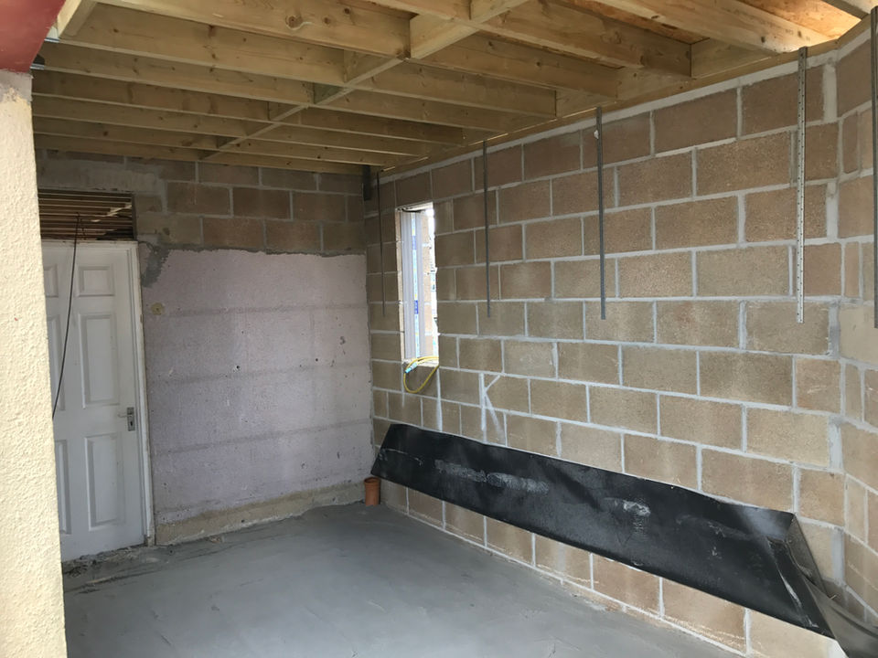 Interior under-construction room, showing brick walls and wood beams