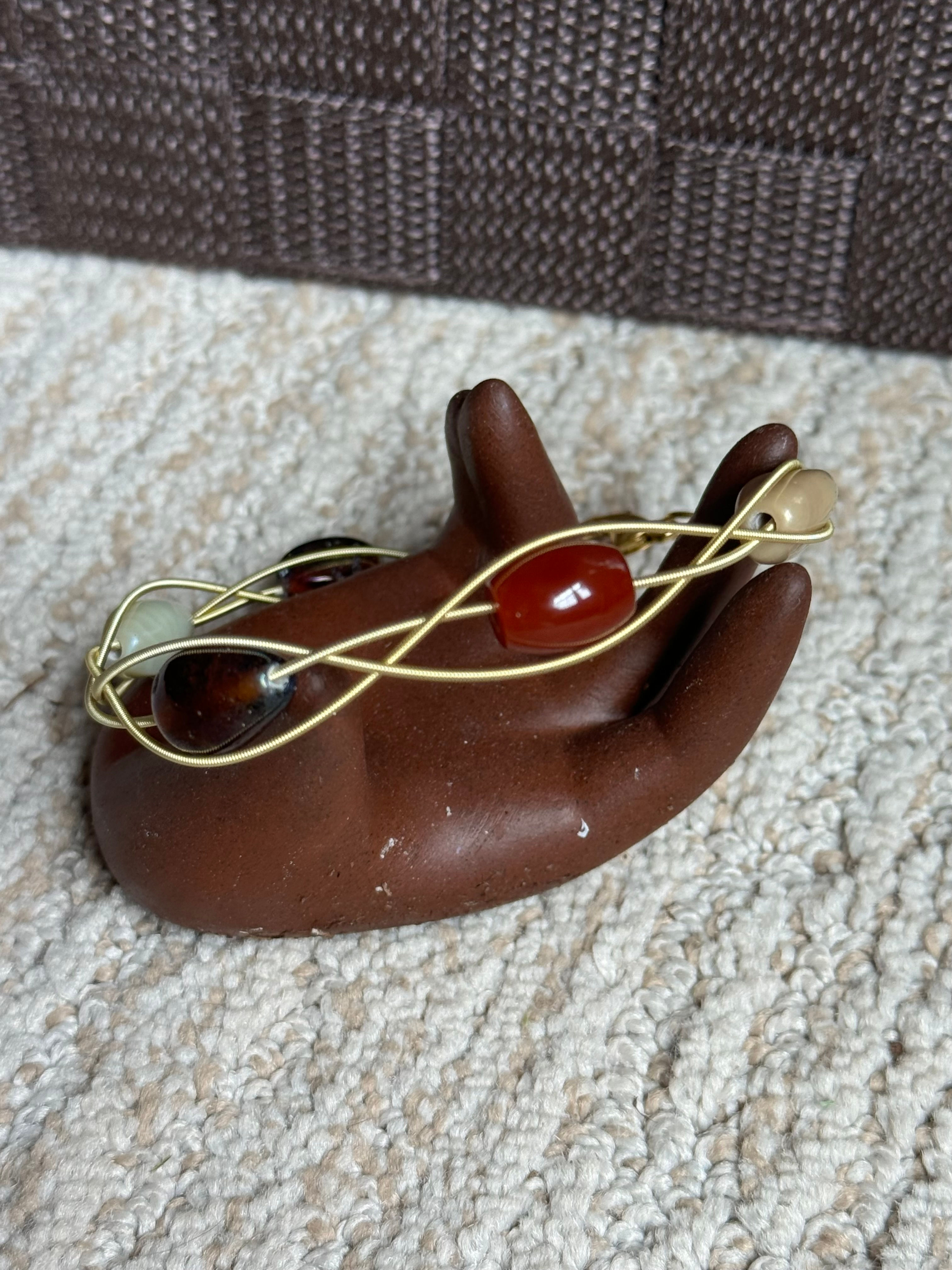 Gold guitar string with brown beads