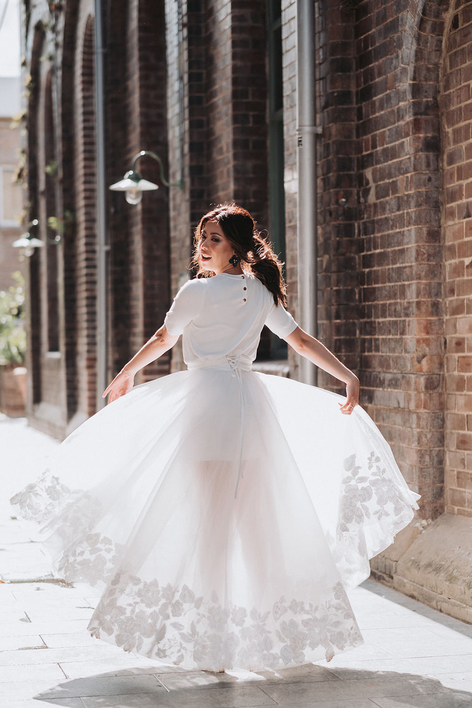 NSW Wedding photographer captures a bride walking in a sunny lane in the Grounds of Alexandria.