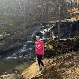 woman with cancer loughing and running near a river