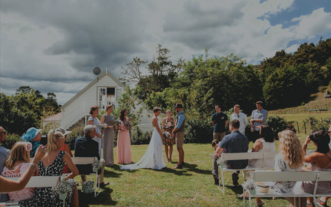 Outdoor country wedding with white cottage and rolling hills in background