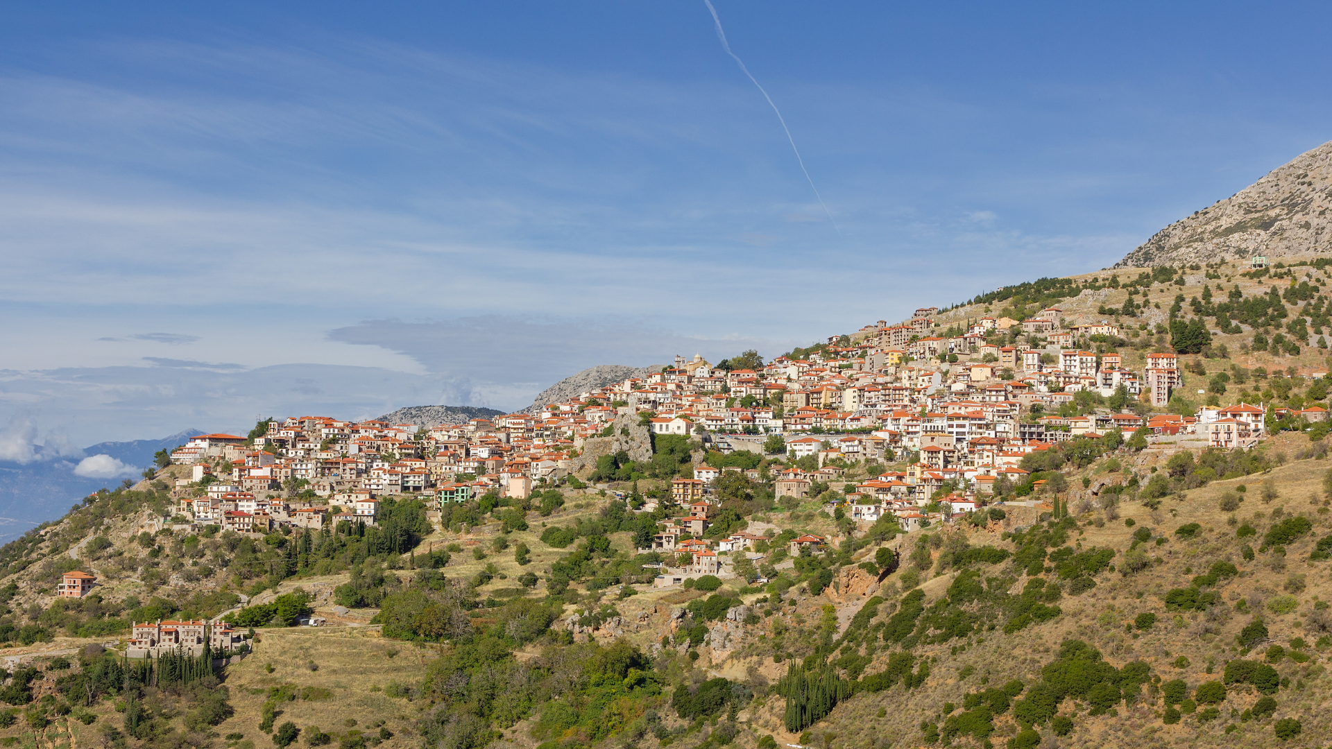 High-angle scenic view of a historical stone village clinging to the green terraced mountain slopes in northern Israel.