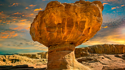 The iconic red sandstone Mushroom rock formation in Timna Park at sunset, showing unique desert erosion in the Arava Valley.