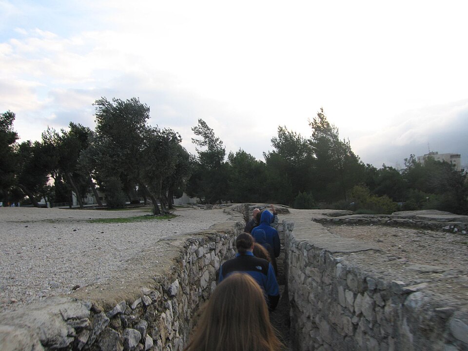 Tourists walking through the narrow historical trenches at Ammunition Hill during a guided Jerusalem tour.