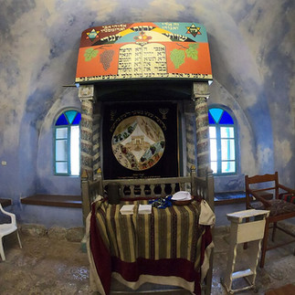 The inner sanctuary of the Ancient Peki'in Synagogue featuring a traditional Torah ark with blue painted walls.