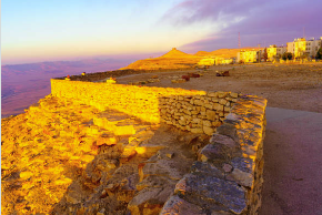 A breathtaking sunset view of the stone fortress walls at Herodium, illuminated by golden light overlooking the Judean Wilderness.