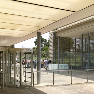Entering the Israel Museum visitor center. A perspective shot of the contemporary glass and stone architecture that welcomes tourists to the museum grounds.