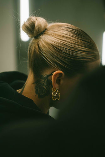 Tattoo-Künstlerin beim Stechen eines Tattoos im Licht von Neonröhren