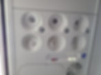 Overhead aircraft panel with air vents, reading lights, and a fasten seat belt/no smoking sign