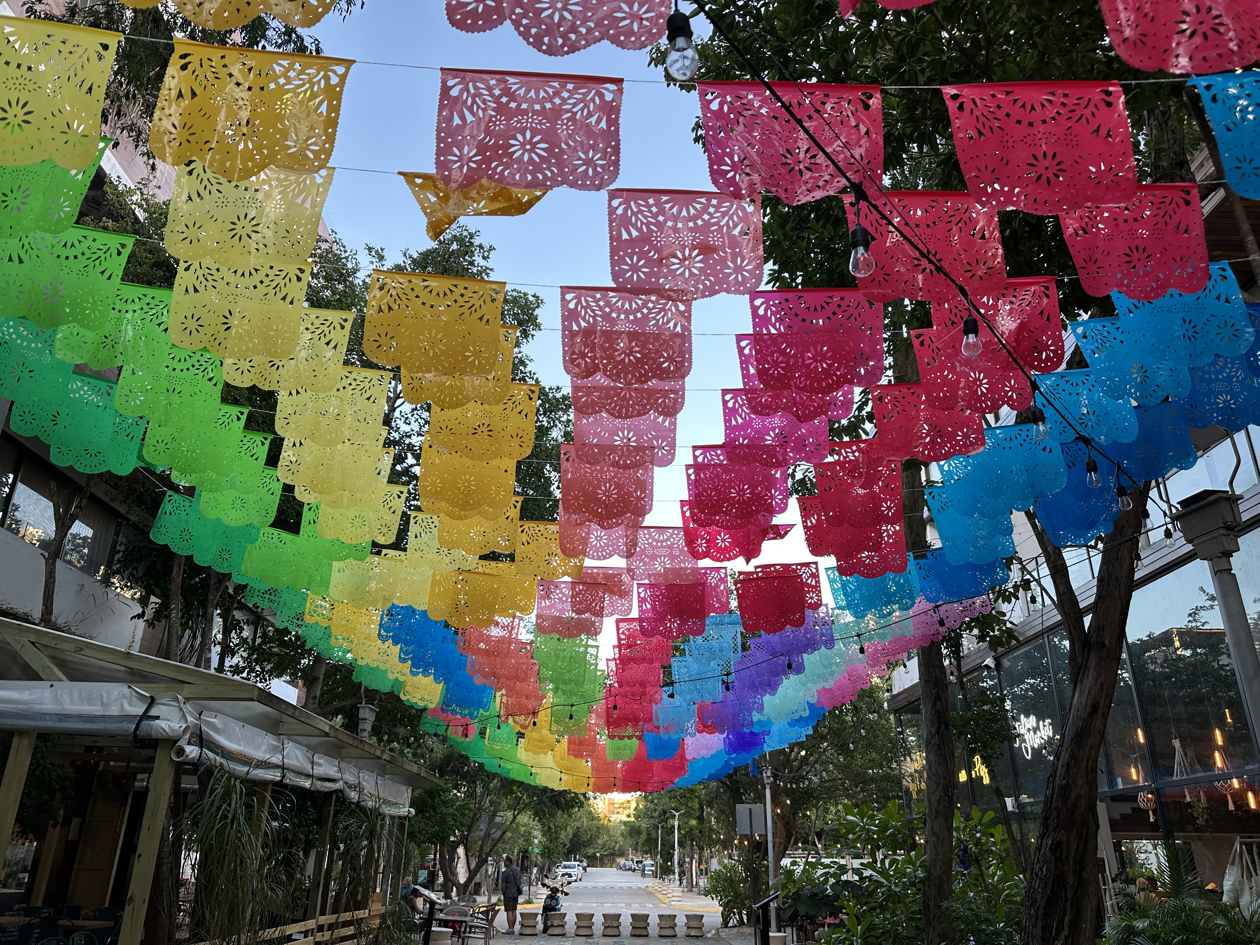 Street view in Aldea Zama with papel picado flags overhead