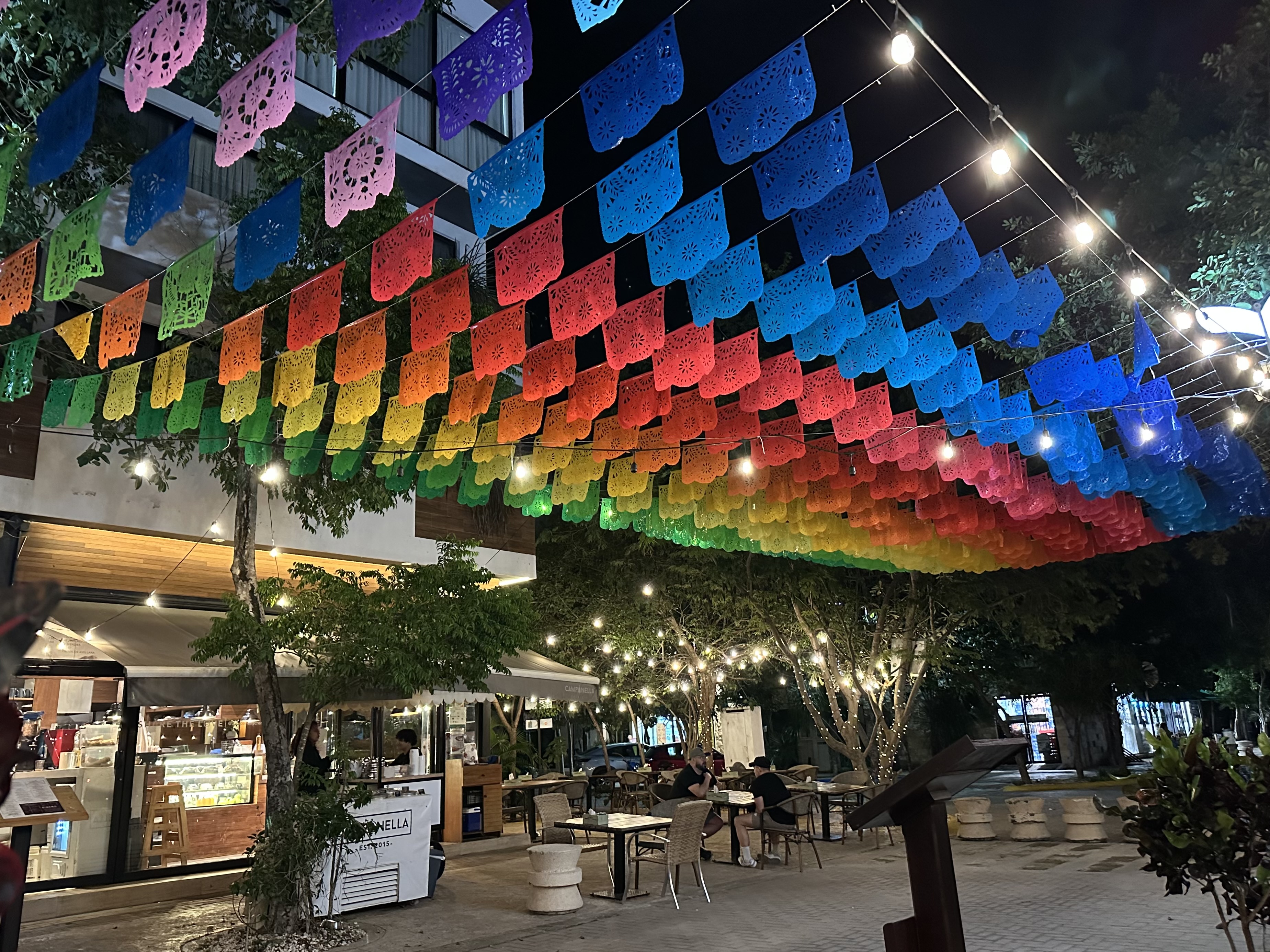 Papel picado flags strung over an Aldea Zama street