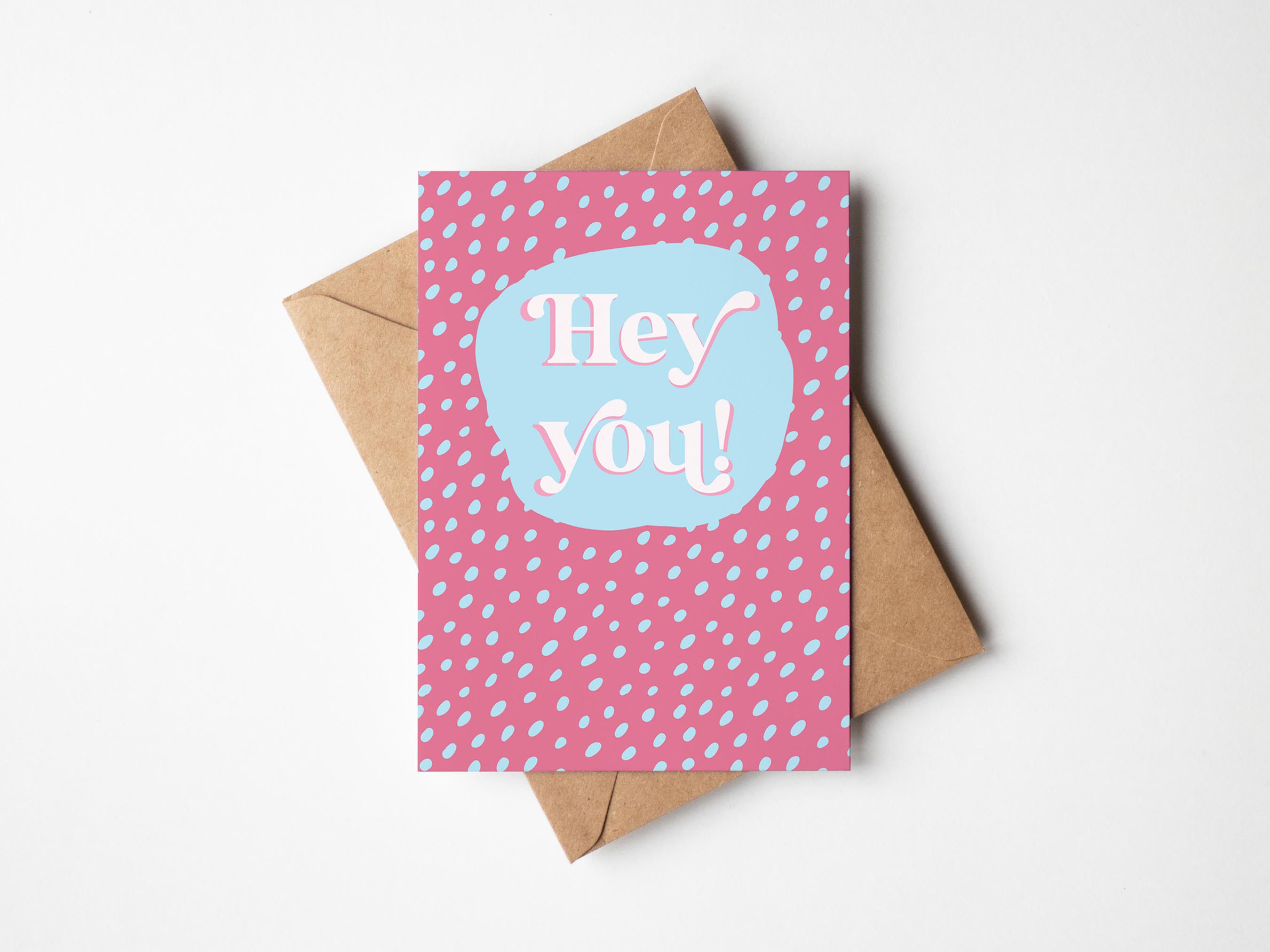 A Hey You! greetings card with the word Hey You on the front, dark pink and light blue