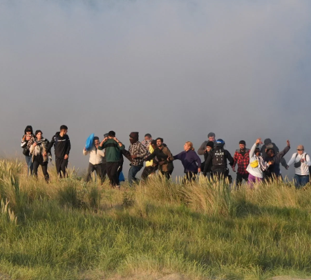 Migrants emerge from bushes on a beach in Gravelines after French police deploy tear gas