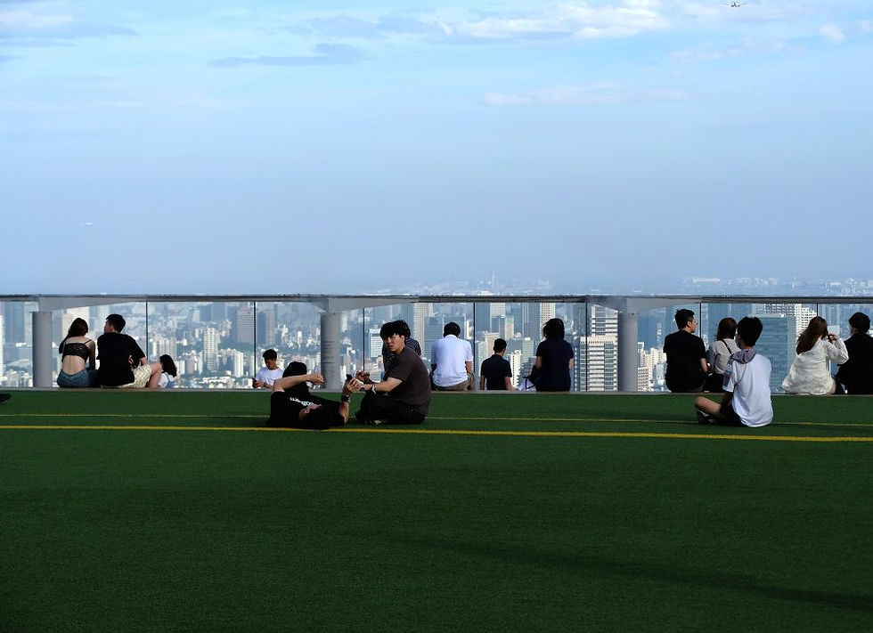 People relax on the artificial grass at Tokyo's Shibuya Sky observation platform