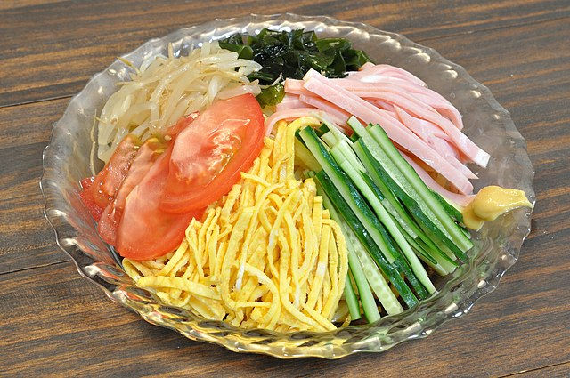 Hiyashi chuka are cold ramen served with a sauce and a salad of vegetables, egg and cold meats on top