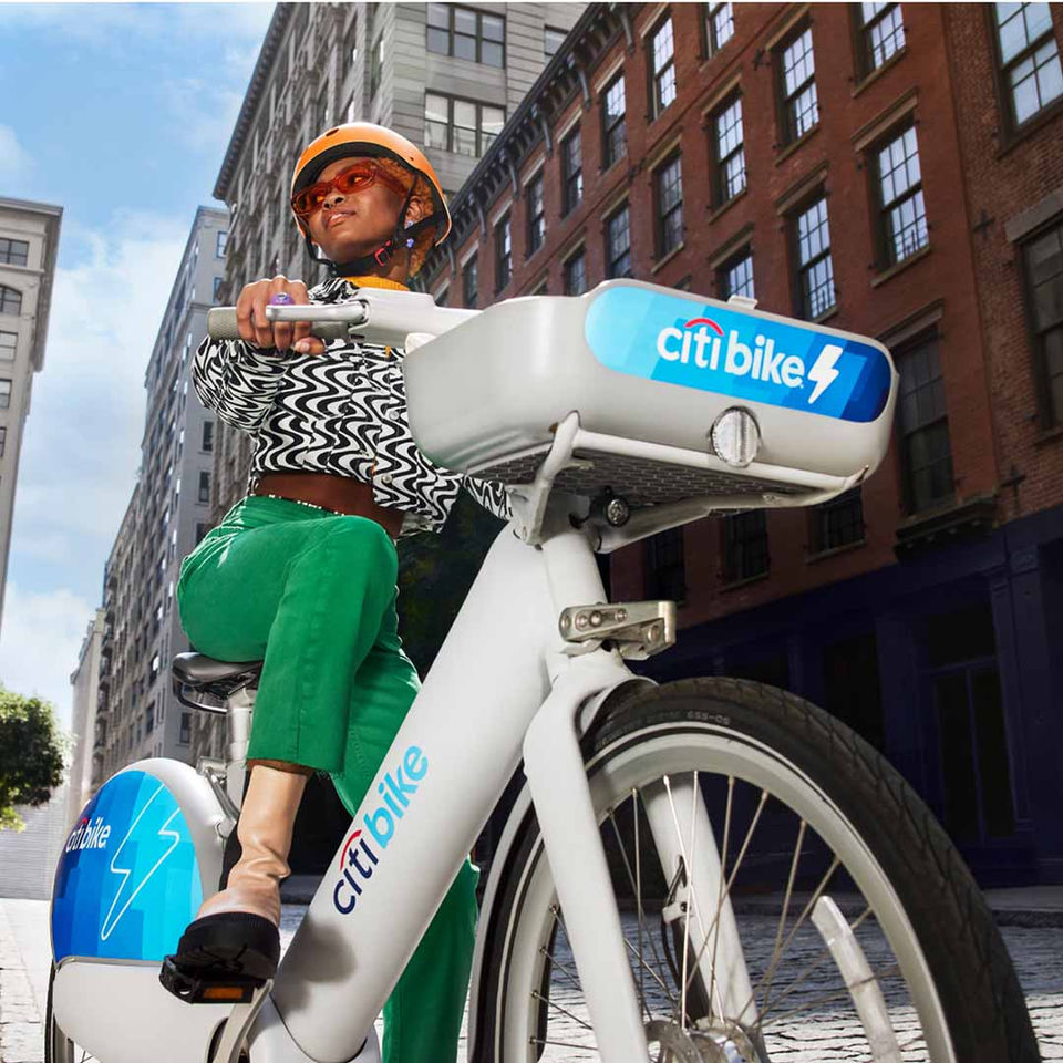A CitiBike rider commutes through New York City streets, showcasing urban biking and sustainable transit in a bold, stylish moment.