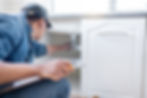 Contractor inspecting kitchen plumbing under sink during home renovation or maintenance to ensure leak-free installation
