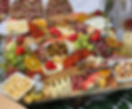 A rectangular sharing board filled with fruit, crackers, cheese and cured meats