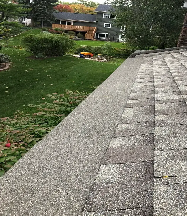 Close-up of a gutter cap installed on a residential gutter, designed to let in rainwater while keeping out leaves and debris