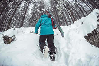 Snowboarder Walking Through Snow