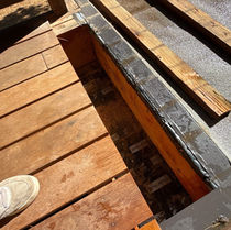 Deck boards lifted to expose the waterproofing membrane and sleepers over the garage roof