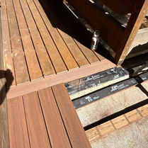 New composite decking meeting the breaker board at the transition to the existing deck section