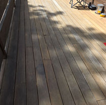 Weathered mahogany decking showing cupping and uneven discoloration before replacement