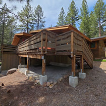 Elevated wood deck wrapping the front of the home above the garage before work began
