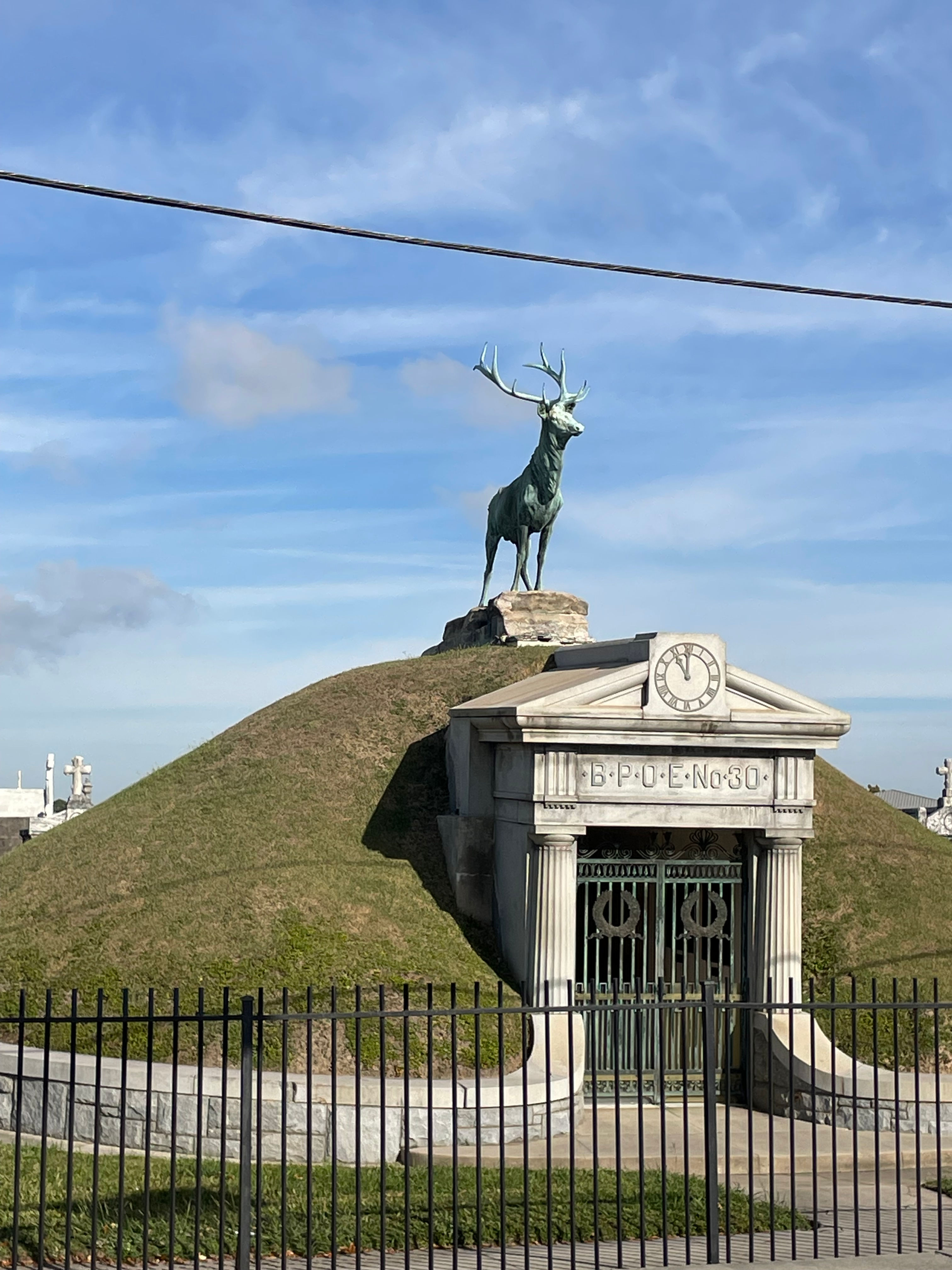 A majestic cathedral facade with two tall towers flanking a large, intricate rose window, set against a clear blue sky.