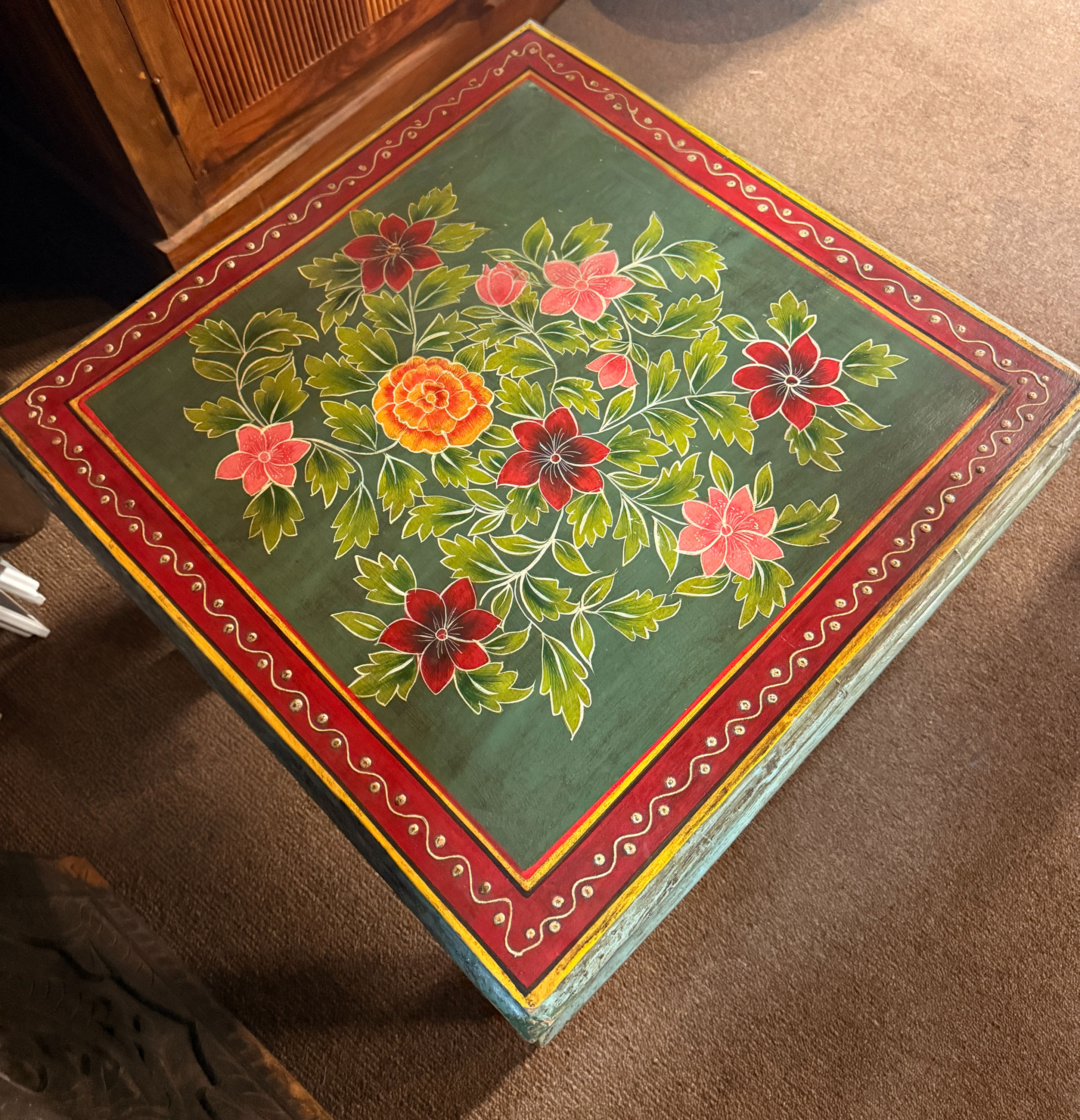 Hand-painted wooden coffee table featuring vintage floral patterns and colorful detailing