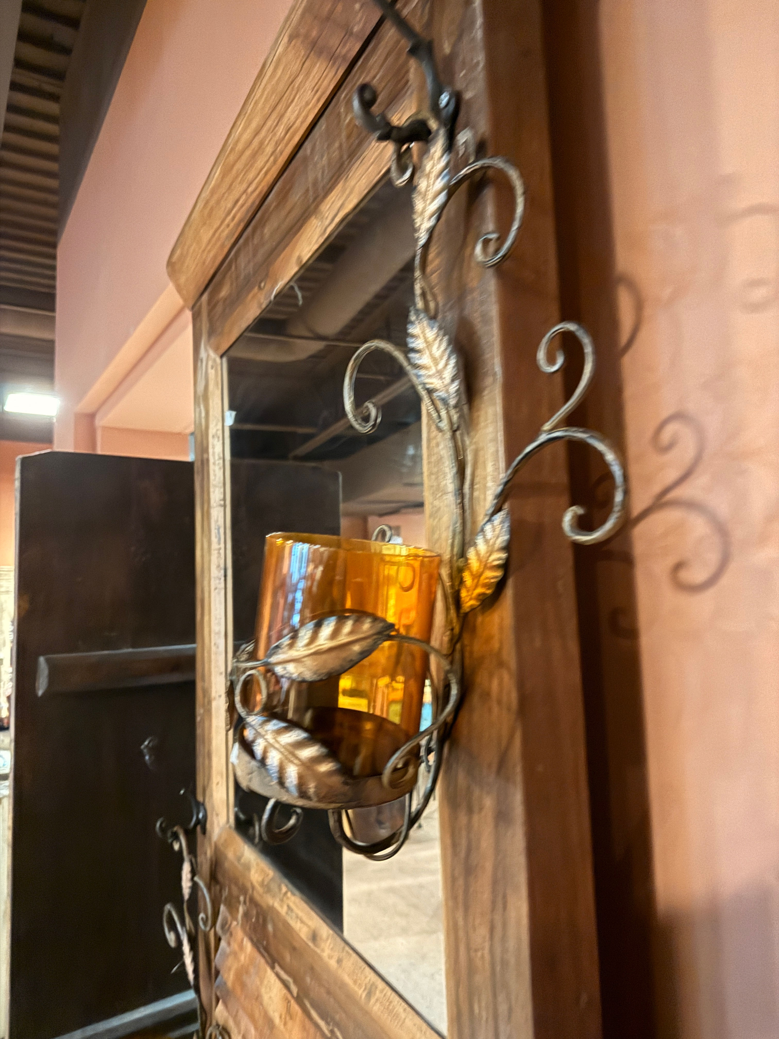 Distressed gold and brown metal wall sconce with ornate leaf and scroll details