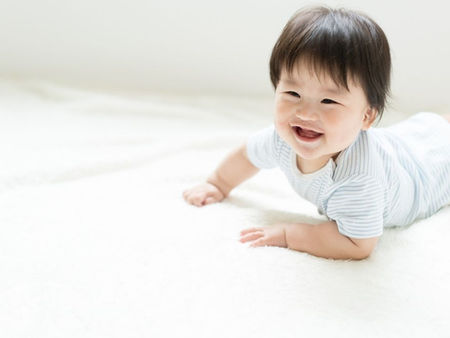 札幌の赤ちゃん整体。片方の足を引きずるようなハイハイの左右差に対し、骨格のバランスや根元の詰まりを優しく調整してスムーズな動きをサポートする施術風景。