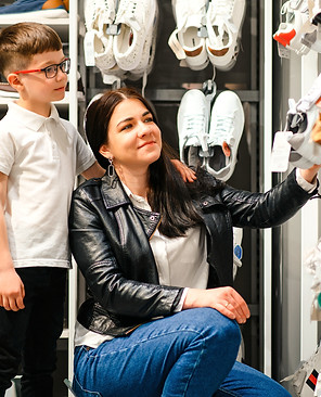 woman-with-child-choosing-and-trying-on-