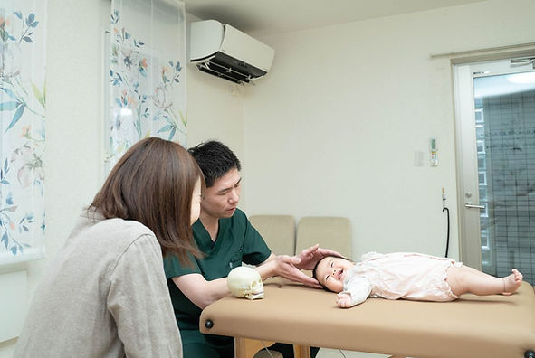 ママに見守られながら赤ちゃんの施術を行う札幌ベビーオステオパシー