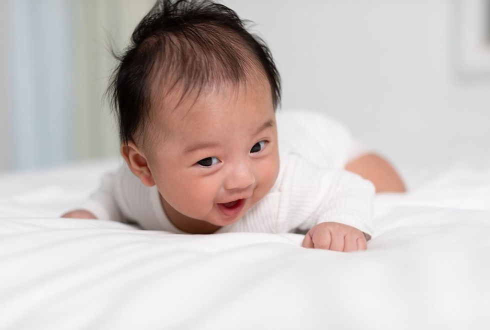 うつ伏せで顔を上げている赤ちゃんの様子。体のバランスや動きの発達をイメージしたシーン